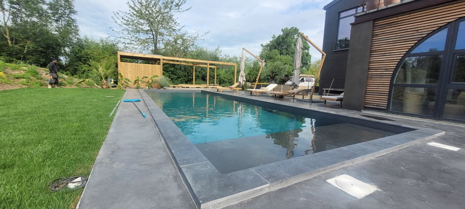 Piscine extérieure et plage en dalles réalisée par Bâti Pool